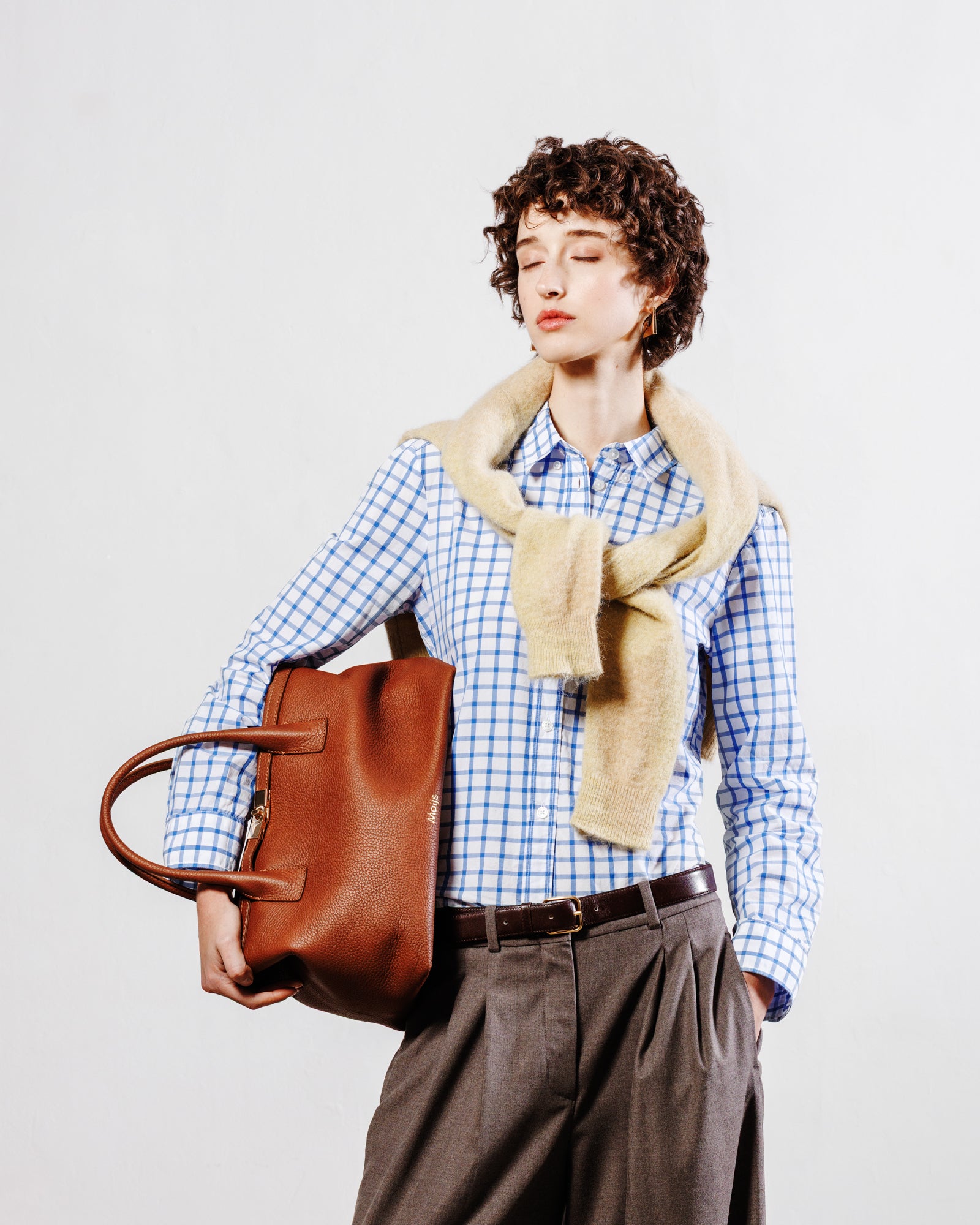 Borsa Moijs in pelle di vitello color cuoio indossata a mano da modella