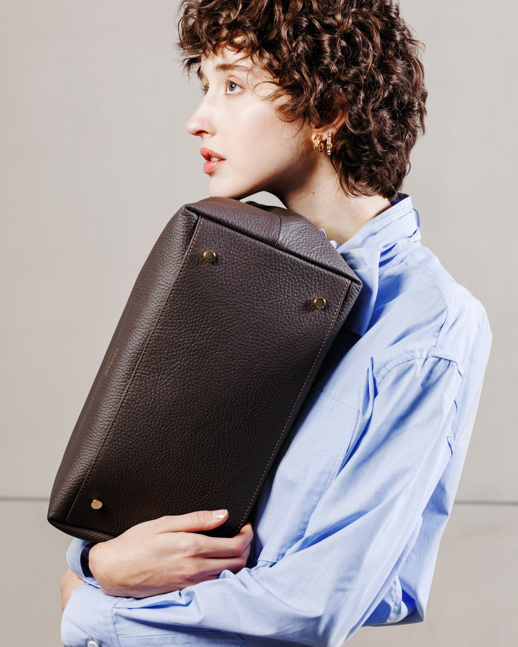 Vista laterale della borsa Khaite marrone in pelle italiana Moijs indossata da modella