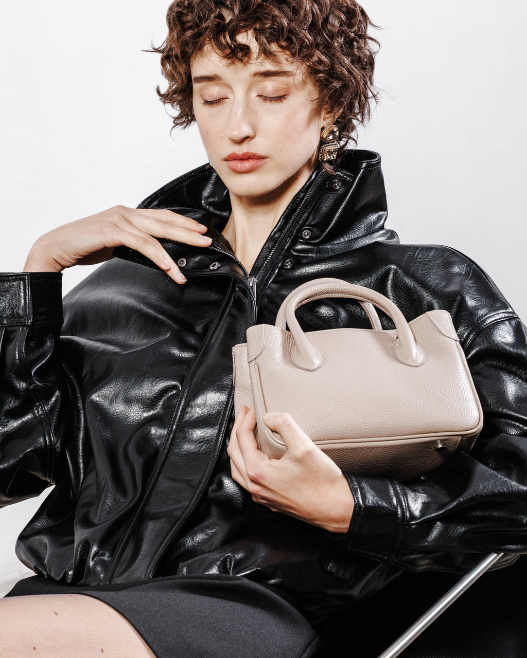 Mini borsa Moijs beige indossata, accessorio artigianale elegante in pelle di vitello